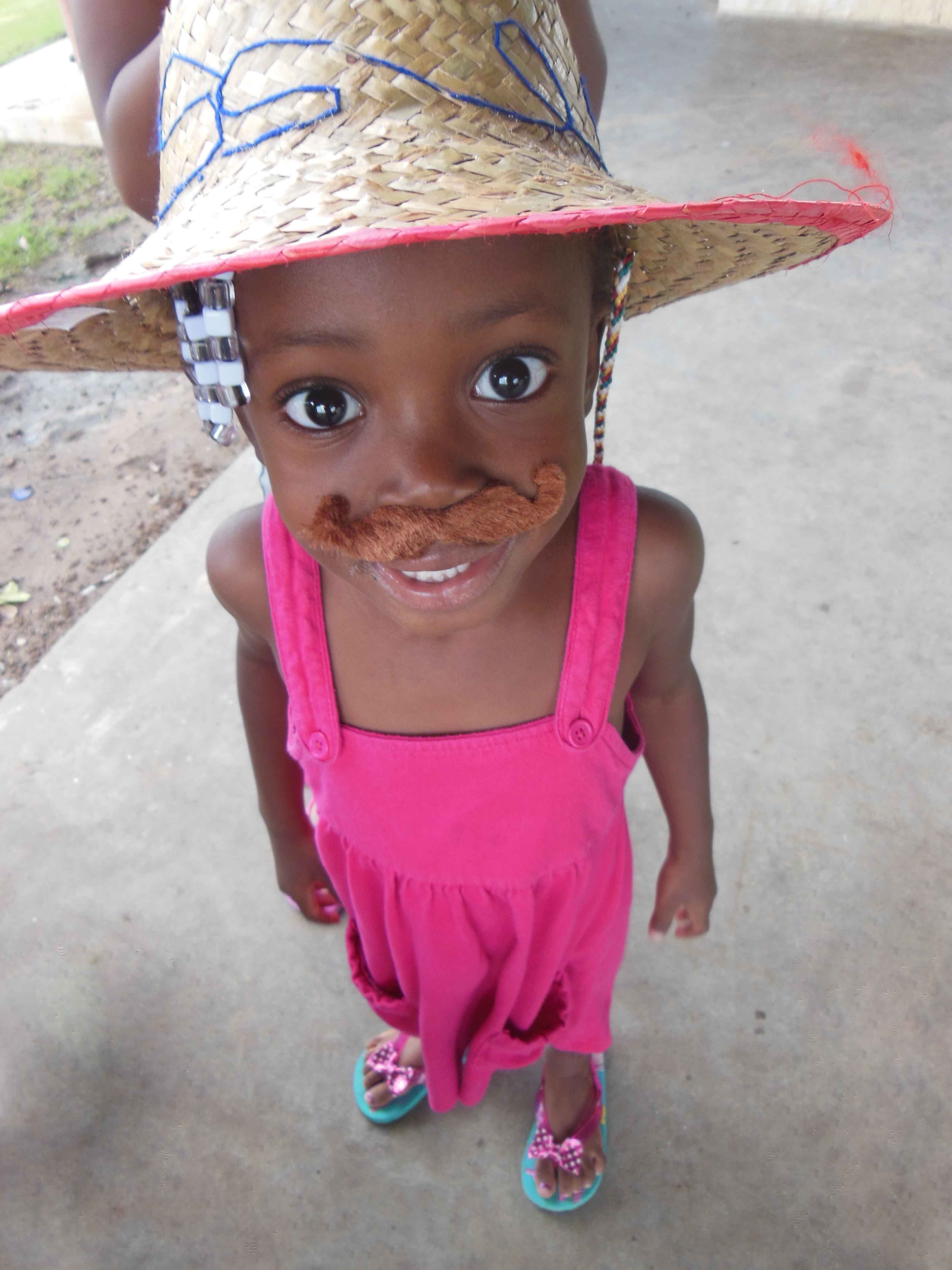 Girl in pink dress and tape on mustache