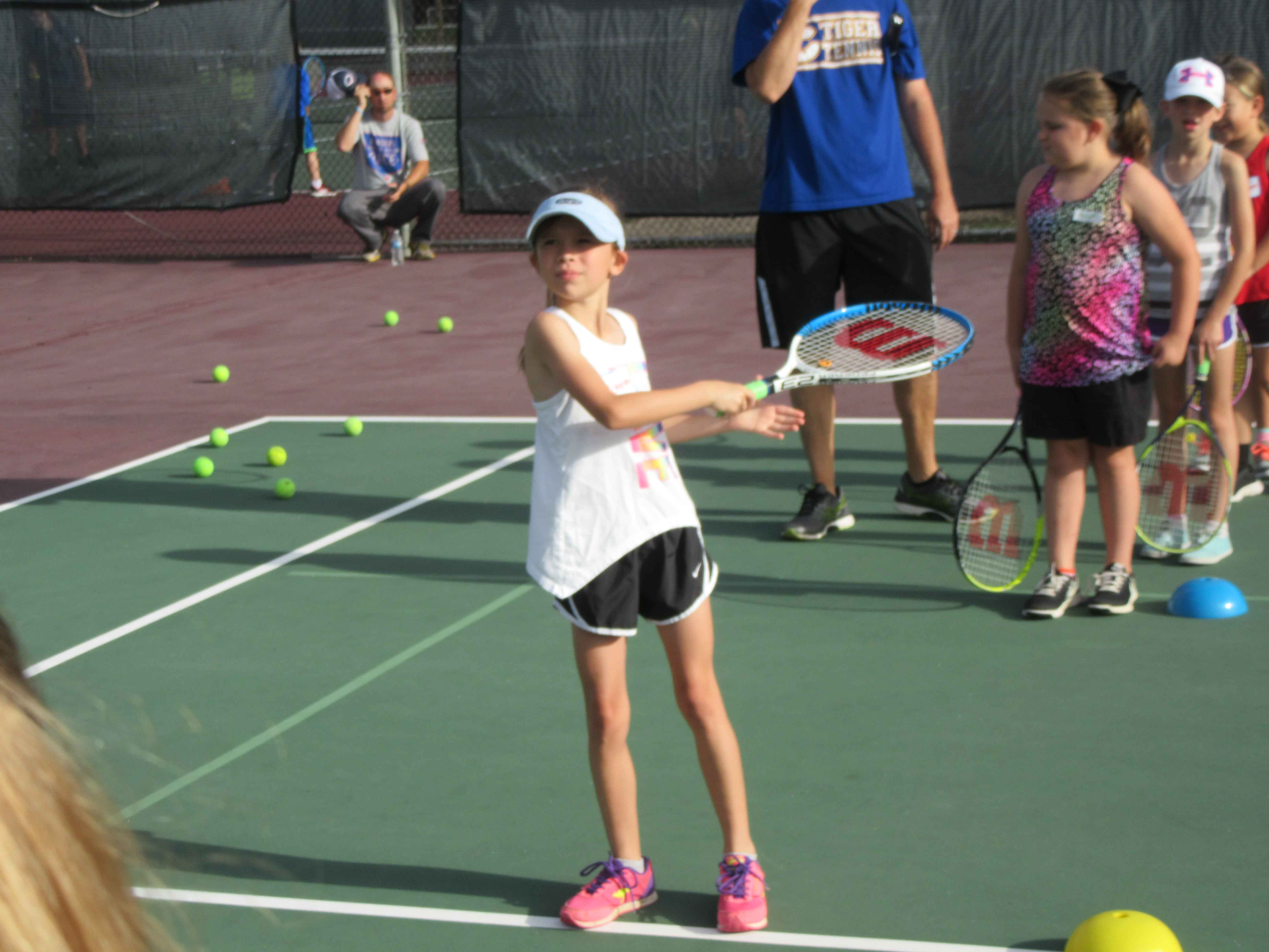 Girl hitting tennis ball