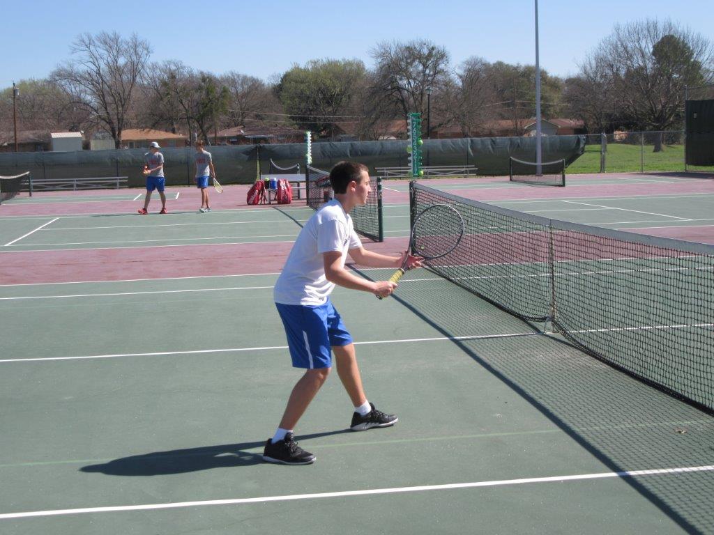 Boy getting ready to hit tennis ball