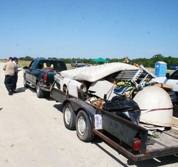 Pickup truck pulling flat bed trailer full of items to be discarded at the Corsicana municipal landf